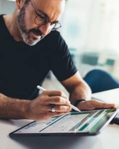 Man working on payroll compliance document on tablet