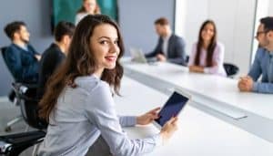 Business woman on tablet looking at camera