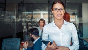 Business woman using tablet in front of her colleagues in the office.