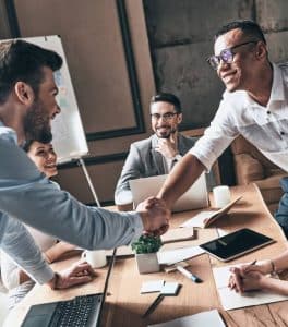 Group of colleagues shaking hands at desk
