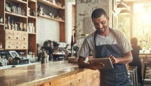 Barista using tablet in coffee shop