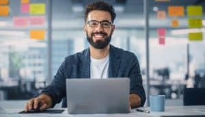 Man sitting at desk with laptop and post it notes